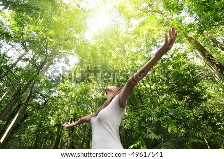 stock photo : Enjoying the nature. Young woman arms raised enjoying the fresh air in green forest.