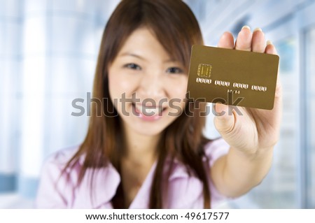 stock photo : Credit card. Asian woman holding a credit card, focus on the