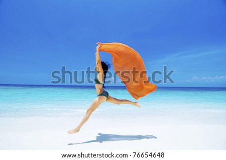stock photo Pretty young bikini girl is jumping up in the air at the beach