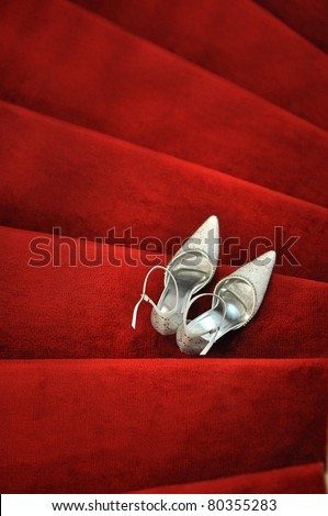 stock photo White bridal shoes on red carpet