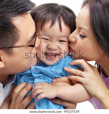 Parents giving their daughter a kiss.