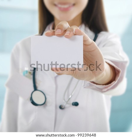 Female doctor showing her name card in front hospital building
