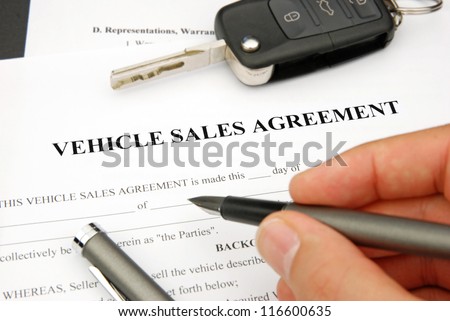 Document and Form of a Vehicle Sales Agreement with Hand signing pen and car key