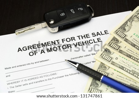 agreement form document for a Sale of motor vehicle with car key, money and pen