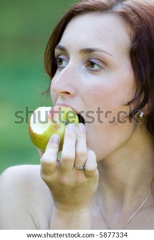 a young woman witch apple  in a park