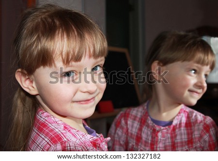 Smiling pretty little girl with mirror reflection. Close up