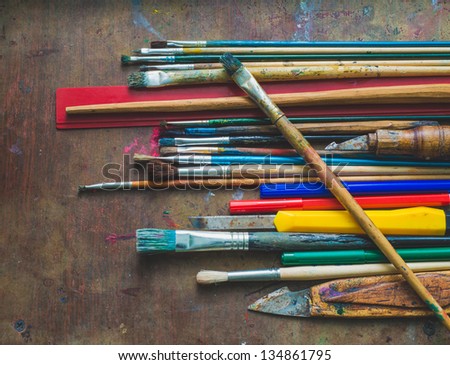 Set of paint brushes and office supplies on the table