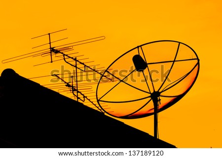 Satellite dish and home TV antenna mounted on the roof. In the evening