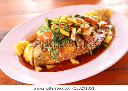 Fried ruby fish topped with sweet,sauer and hot sauce on dish