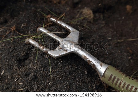 close-up of small gardening fork on the soil