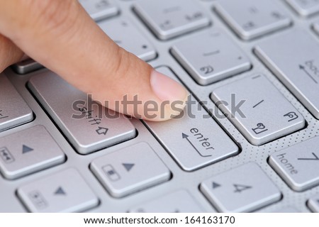 close-up finger pushing the enter button of keyboard