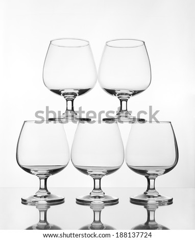 stack of empty wine glass on glass table (gray scale)