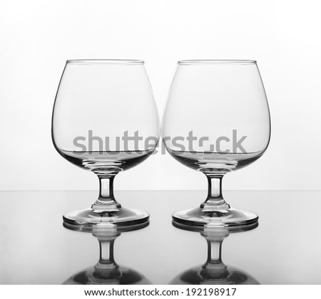 two empty wine glass on glass table (gray scale)