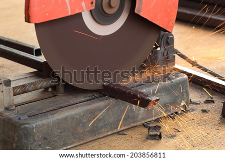 Worker cutting metal with cutting machine