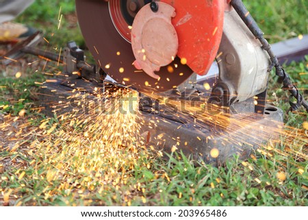 Worker cutting metal and spark with cutting machine