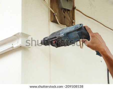 worker using drill to attach panel to wall