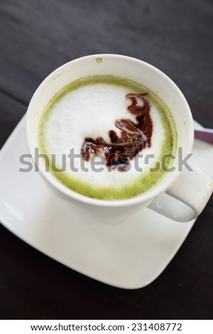 Cup of hot matcha green tea latte with milk cream