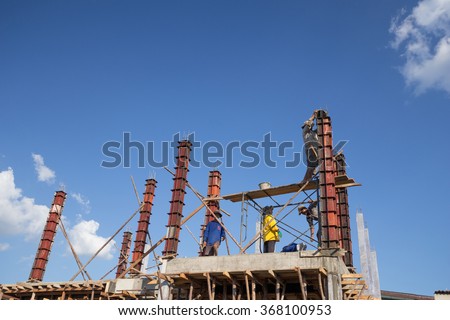 NAKHON RATCHASIMA -DEC 28 : worker pouring cement to concrete pillar mold for house construction on December 28, 2015 in Nakhon Ratchasima, Thailand