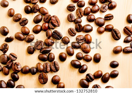 a lot of coffee beans over wood background