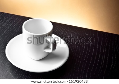 empty cup on the wooden table and golden background