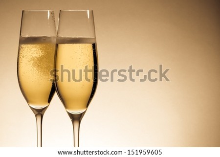 two glasses of champagne with golden bubbles and space for text