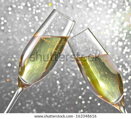 champagne flutes make cheers on silver light bokeh background