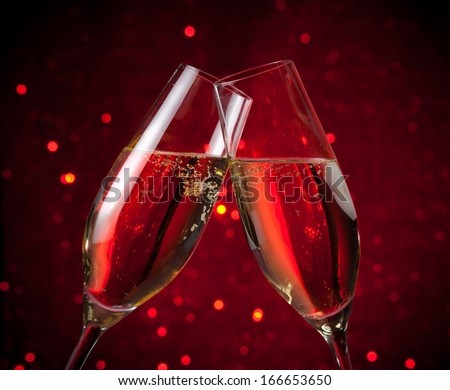 two champagne flutes make cheers on red dark light bokeh background, valentine and christmas events