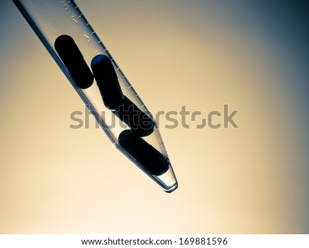 silhouette of blue pills in test tube, health care concept on yellow and blue background with space for text