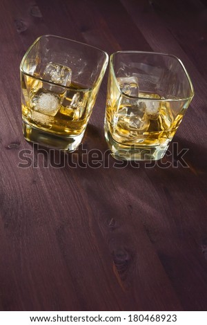 two glasses of whiskey on old wood background
