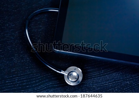 top of view of medical stethoscope near modern digital tablet pc in laboratory on wood table. Concept of medical or research theme