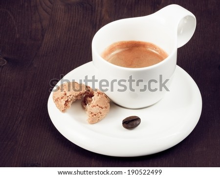 cup of italian espresso coffee and biscuit near coffee bean on old wood