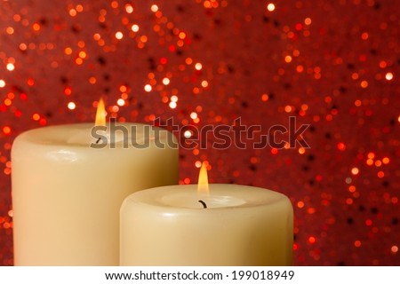candles with flame on red bokeh background and space for text