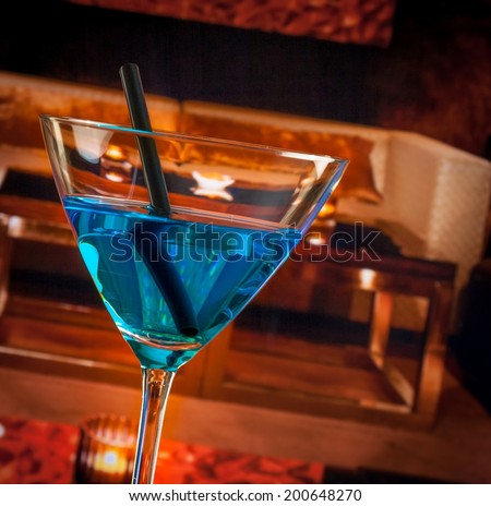 detail of blue cocktail drink on a lounge bar table, club atmosphere