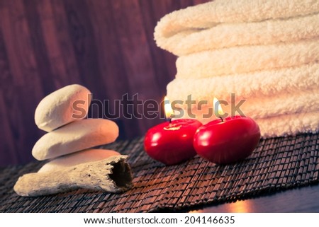 Spa massage border background with towel stacked stone and red candles on wood background warm atmosphere