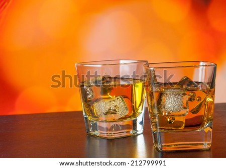 whiskey glass with ice on bar table on warm atmosphere lounge bar concept