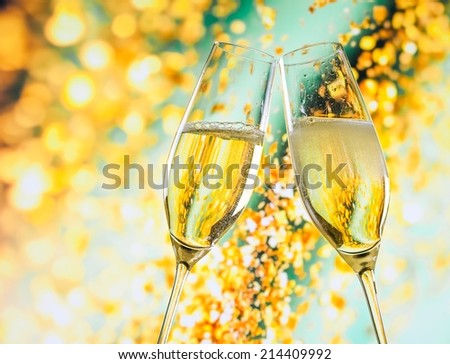 a pair of champagne flutes with golden bubbles make cheers on golden light background with space for text