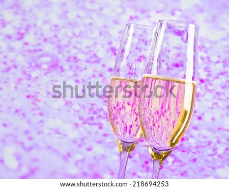 champagne flutes with gold bubbles on blur violet tint light background love concept