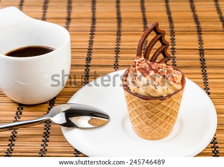 delicious little coffee cake with chocolate near a cup of coffee on wood background