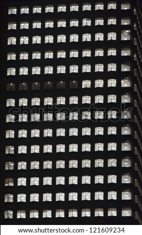 window of the night empty multi-storey skycraper building of glass and steel office lighting and with no people within