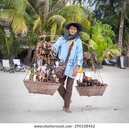 Koh Chang, THAILAND - MARCH 12: An elderly woman sells to tourists souvenirs on the beach, Thailand, on March 12, 2015.