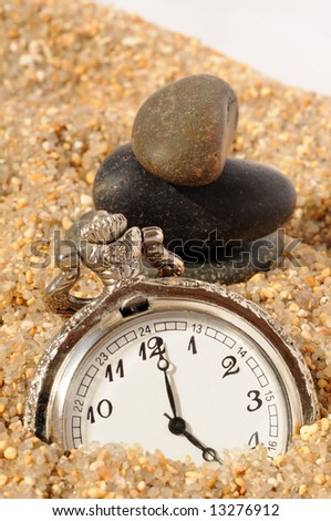 watch in the sand and stones pyramid. time concept