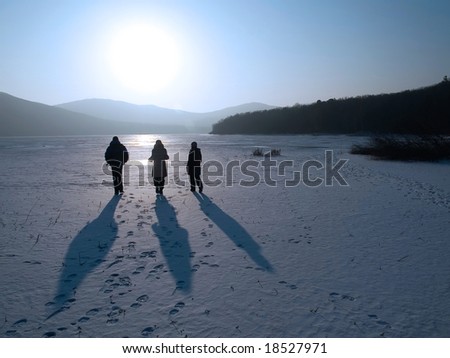 group of friends going ahead on the frozen lake to the sun