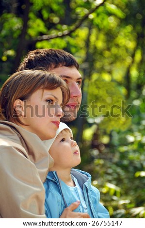 young family in the park looking far away