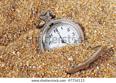 vintage pocket watch in the sand. time concept