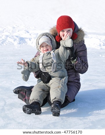 happy family of mother with baby playing in the snow winter park