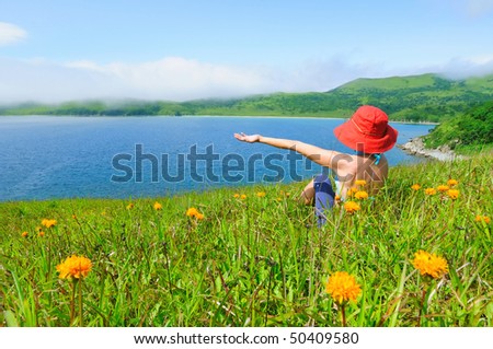 happy girl on the flower meadow against the sea  landscape