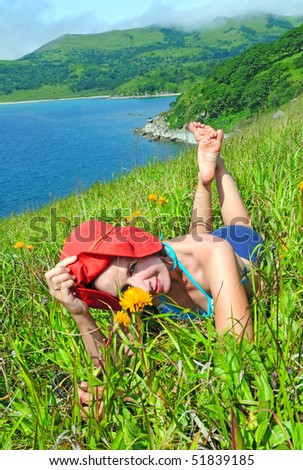 happy girl on the flower meadow against  the sea landscape