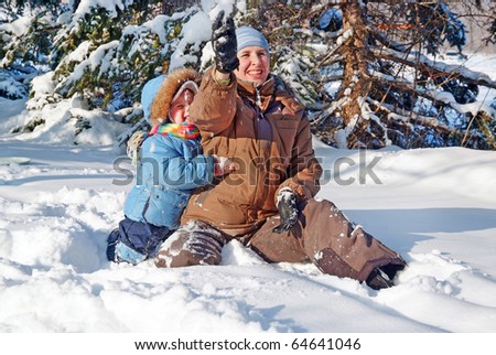 happy family of mother with kid playing in the snow winter park