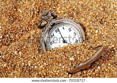 vintage pocket watch in the sand. time concept