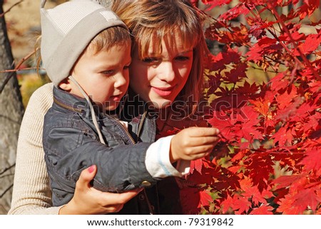 family of mother with kid teaching botany in the fall forest